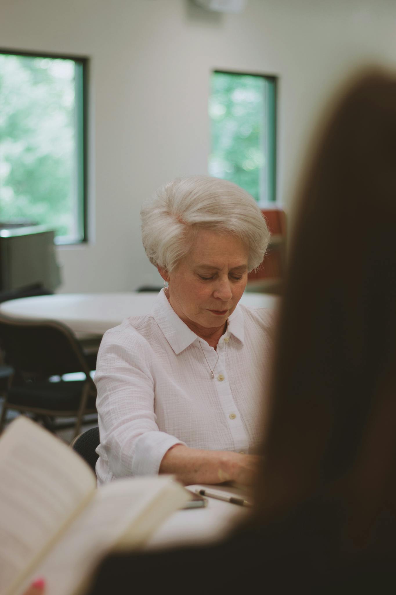 A woman studies the Bible in a church setting, highlighting community and faith.