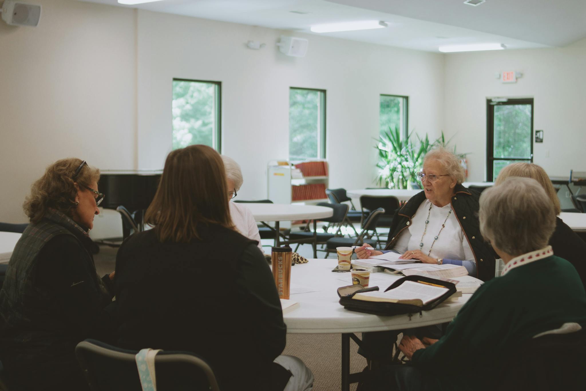 Older women engage in a thoughtful Bible study session at a local church in Brevard, NC.