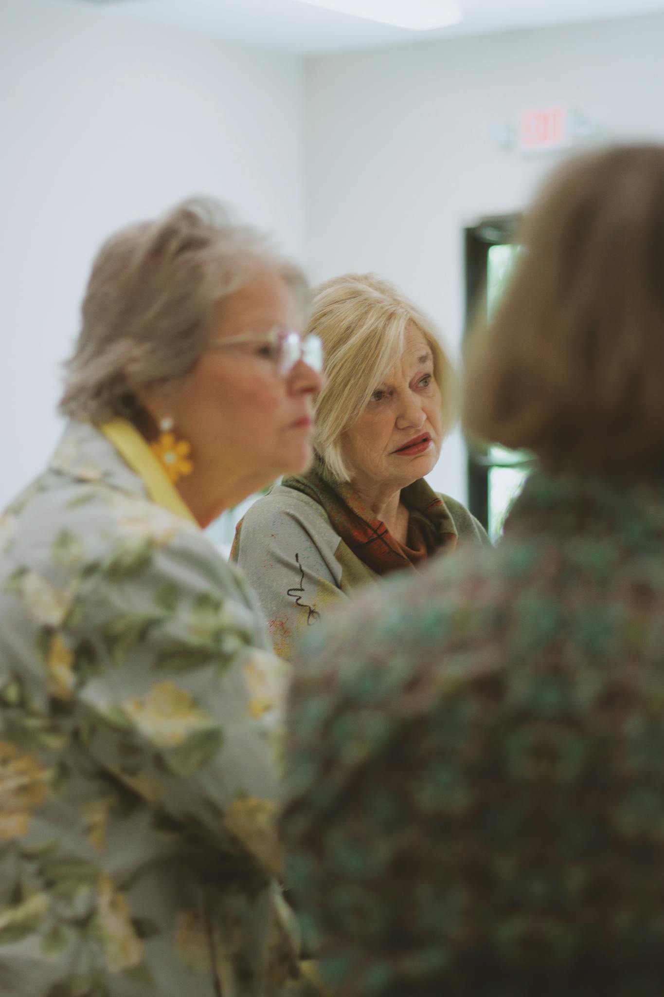 Two elderly women engaged in a Bible study session indoors.